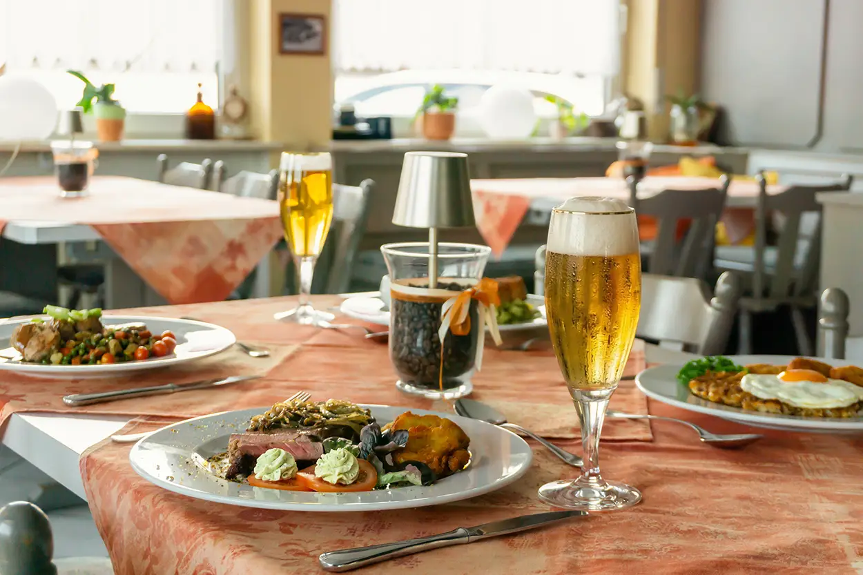 Reich gedeckter Tisch mit Rumpsteak, Schnitzel und frisch gezapftem Bier in gemütlicher Atmosphäre im Landgasthof Gottmann