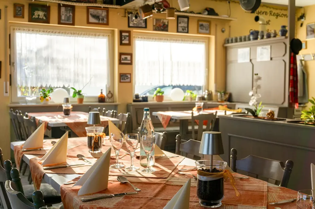 Blick in den gemütlichen Gastraum des Landgasthof Gottmann mit liebevoll gedeckten Tischen und warmem Tageslicht