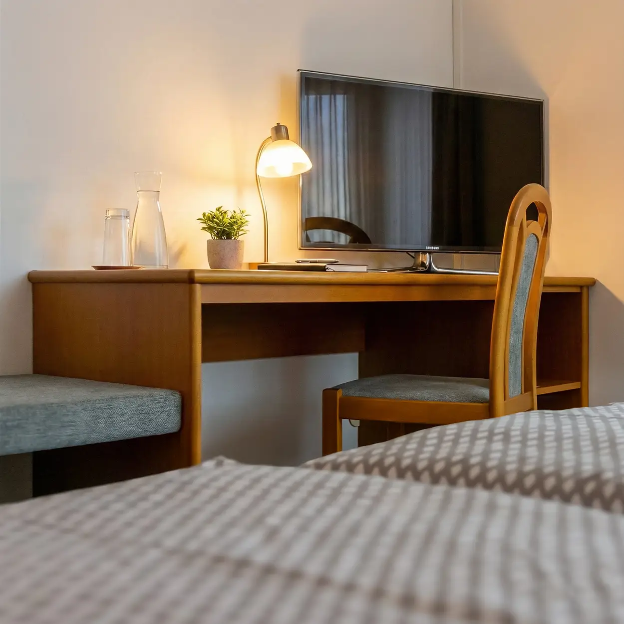Arbeitsplatz mit Schreibtisch, Flachbildfernseher und gemütlicher Beleuchtung im Hotelzimmer des Landgasthof Gottmann
