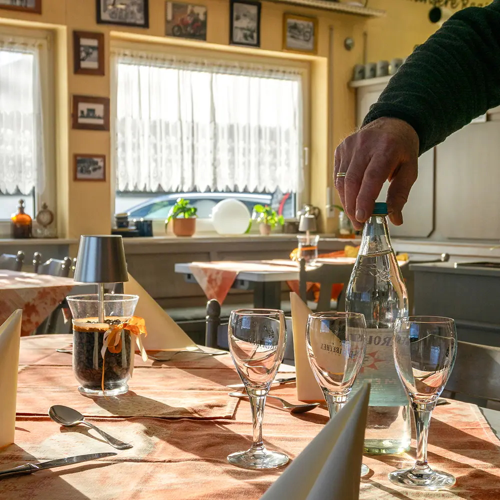 Service am Gast: Eine Flasche Mineralwasser wird auf dem liebevoll eingedeckten Tisch im Landgasthof Gottmann serviert